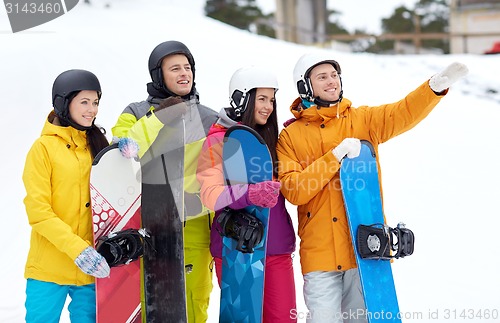 Image of happy friends in helmets with snowboards