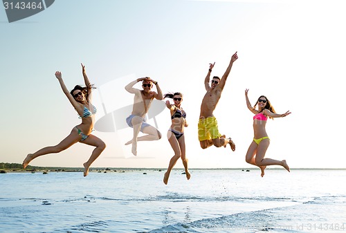 Image of smiling friends in sunglasses on summer beach