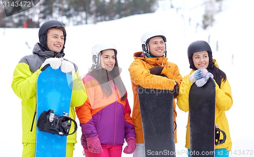 Image of happy friends in helmets with snowboards