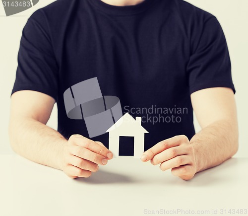 Image of man hands holding paper house