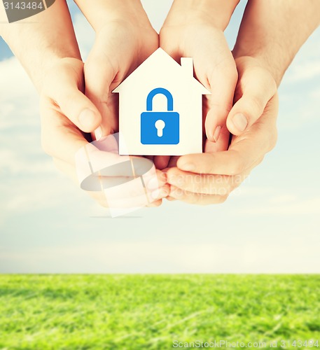 Image of hands holding paper house with lock