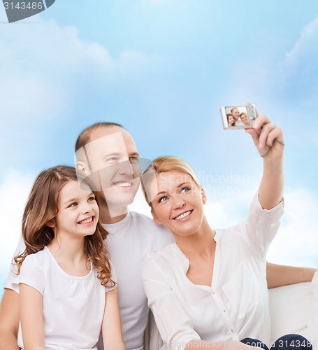 Image of happy family with camera at home