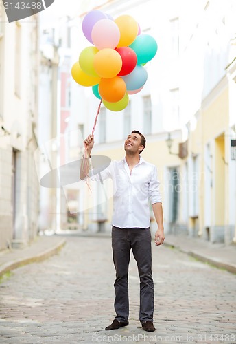 Image of man with colorful balloons in the city
