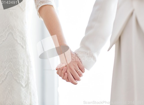 Image of close up of happy married lesbian couple hugging