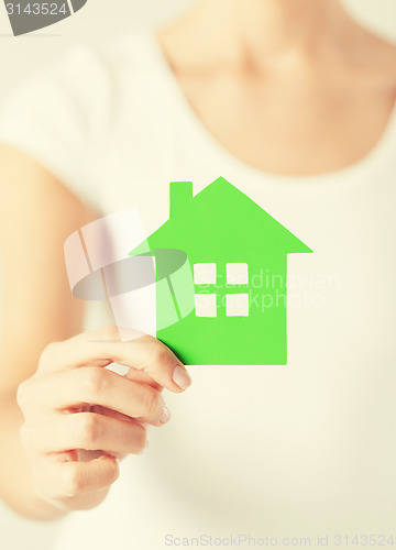 Image of woman hands holding green house