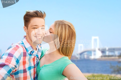 Image of couple kissing and taking selfie over bridge