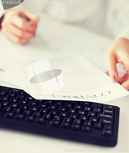 Image of woman hand signing contract paper