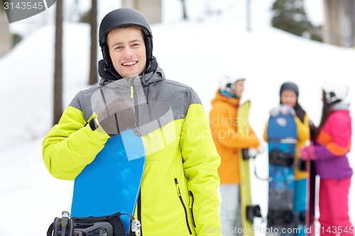 Image of happy friends in helmets with snowboards