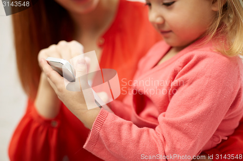 Image of close up of woman and little girl with smartphone