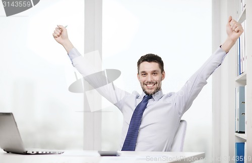 Image of smiling businessman with laptop and documents