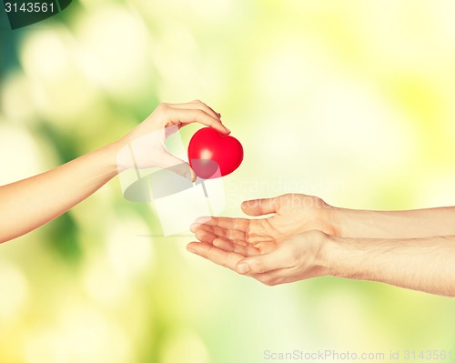 Image of woman and man hands with heart