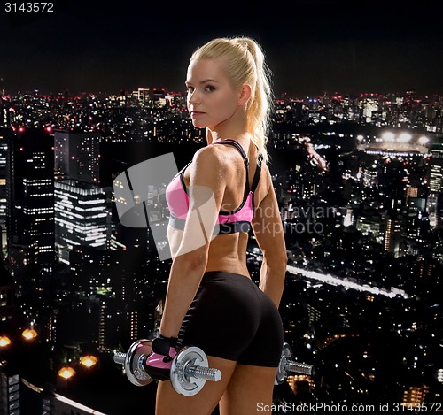 Image of sporty woman with heavy steel dumbbells