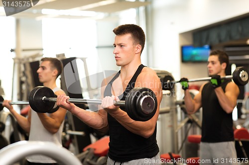 Image of group of men with barbells in gym