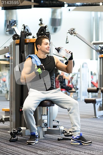 Image of smiling man exercising on gym machine