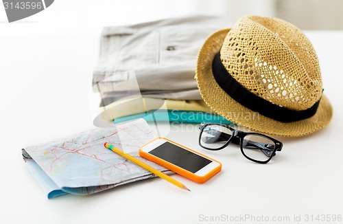 Image of close up of summer clothes and travel map on table