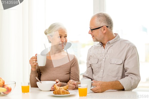 Image of happy senior couple having breakfast at home