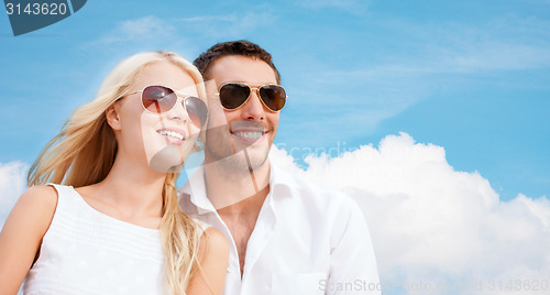Image of happy couple in shades over blue sky background