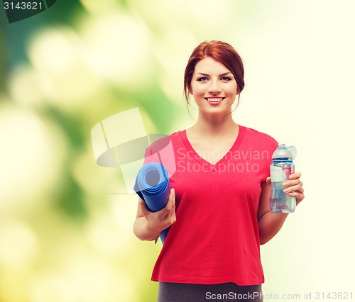 Image of smiling girl with bottle of water after exercising