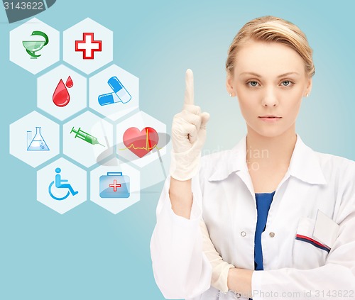 Image of smiling young female doctor pointing her finger up