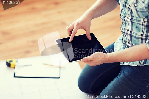 Image of male with tablet pc, blueprint and measuring tape