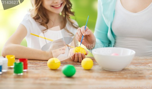 Image of close up of family coloring easter eggs