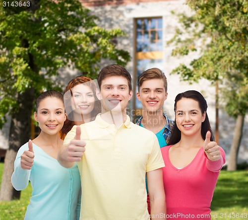 Image of group of smiling teenagers over campus background