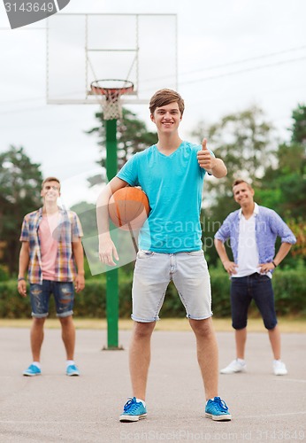 Image of group of smiling teenagers playing basketball