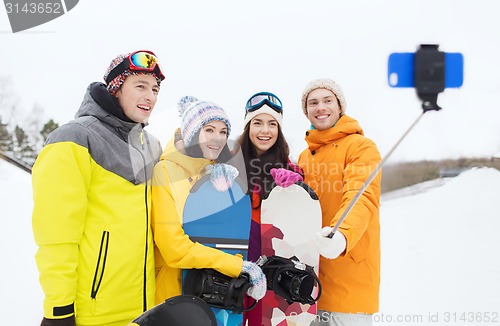 Image of happy friends with snowboards and smartphone