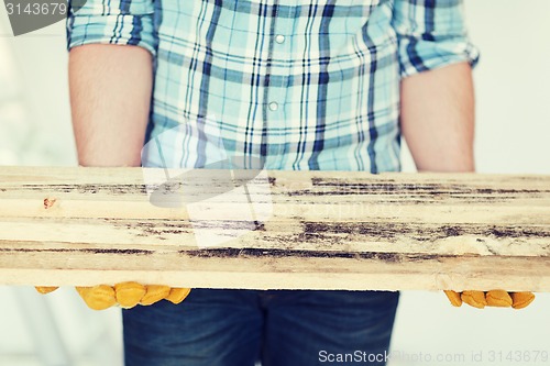 Image of close up of male in gloves carrying wooden boards