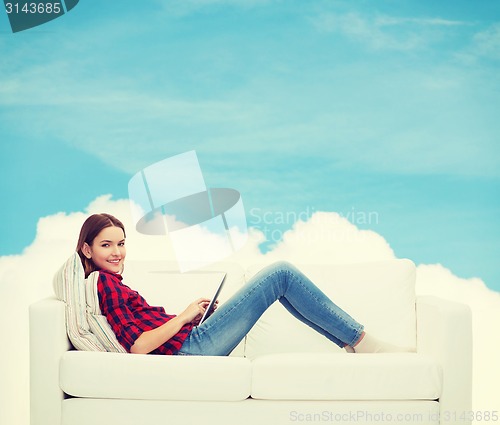 Image of teenage girl sitting on sofa with tablet pc