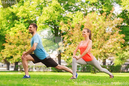 Image of smiling couple stretching outdoors