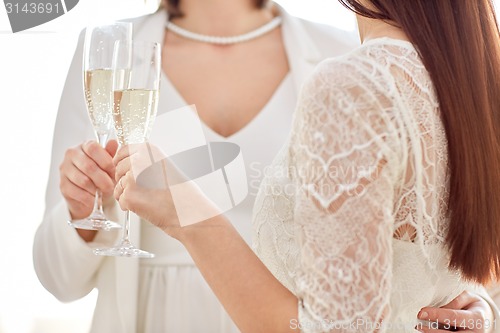 Image of close up of lesbian couple with champagne glasses