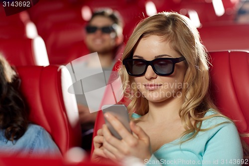 Image of happy woman with smartphone in 3d movie theater