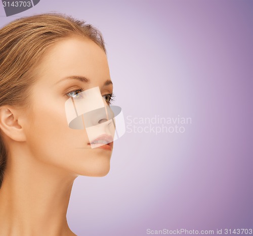 Image of beautiful young woman face over violet background