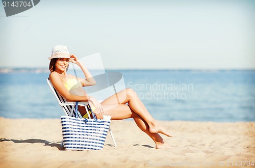 Image of girl sunbathing on the beach chair