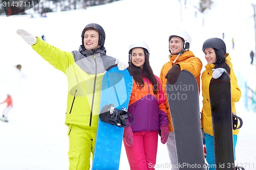 Image of happy friends in helmets with snowboards