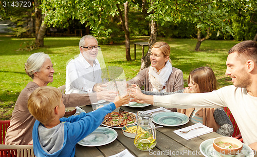 Image of happy family having dinner in summer garden