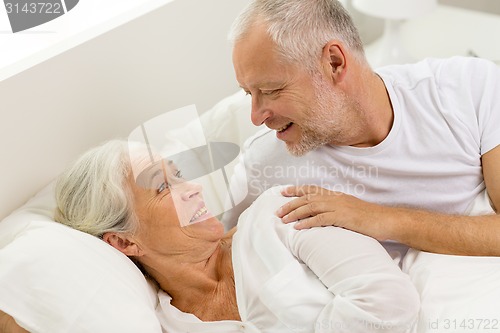 Image of happy senior coupler lying in bad at home