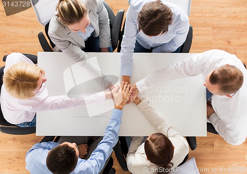 Image of close up of business team with hands on top