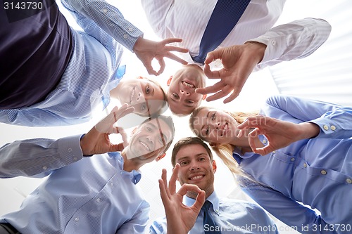 Image of smiling group of businesspeople standing in circle