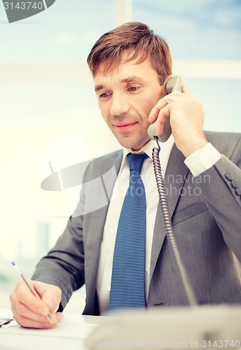 Image of businessman with phone and documents