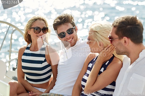 Image of smiling friends sitting on yacht deck