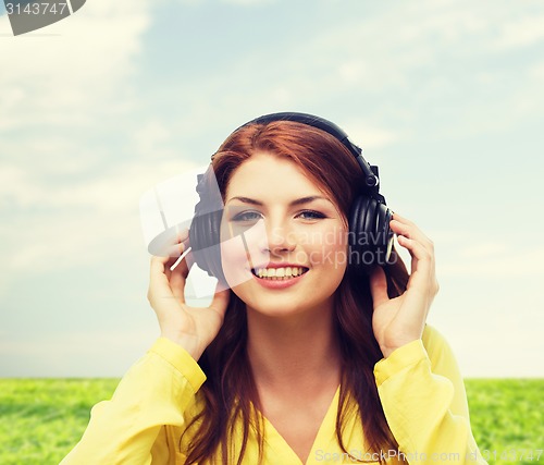 Image of smiling young girl in headphones at home