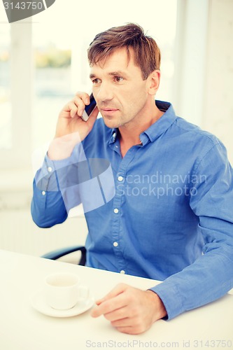 Image of buisnessman with cell phone and cup of coffee
