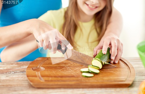 Image of close up of happy family making dinner in kitchen