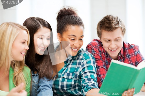 Image of students reading book at school