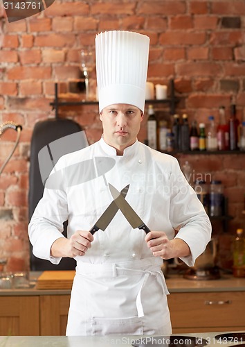 Image of happy male chef cook in kitchen with knife