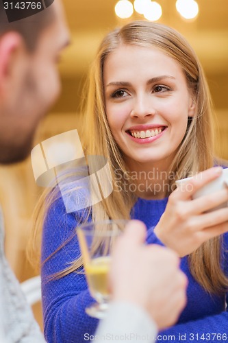 Image of happy couple dating and drinking tea at cafe