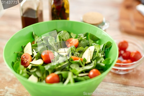 Image of close up of salad bowl and spices on kitchen table