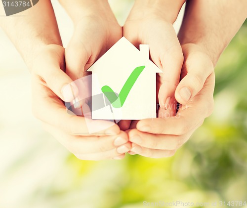 Image of hands holding house with check mark